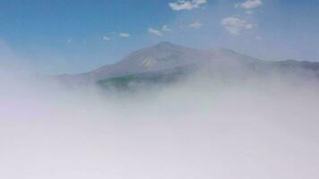 Flying above the clouds over the island of Tenerife - a view of the settlements and the Teide volcano. Canary Islands video