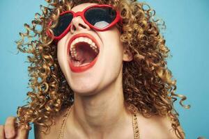 Portrait of a woman curly hair wide open mouth close-up studio sunglasses photo