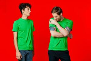 two men in green t-shirts laugh communication joy photo