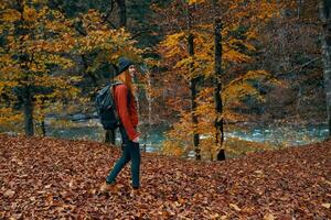 woman in full growth walking in the park in autumn in nature near the river photo