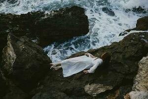 Barefoot woman in white wedding dress on sea shore wet hair view from above photo