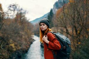 mujer turista mochila otoño bosque río viaje foto