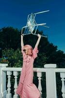 fashionable woman pink dress modern style stands near the railing Lifestyle photo