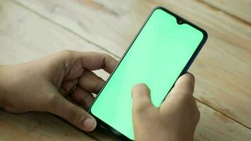 mão usando inteligente telefone exibição verde tela em mesa video