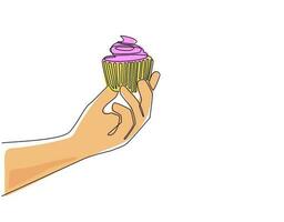 Continuous one line drawing hand holding cupcake. Birthday cake in party. Holiday celebration concept. Surprise and joyful with sweet whipped cream baked. Single line draw design vector illustration