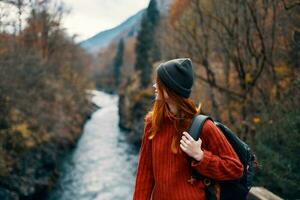 woman with backpack admires the river in the mountains nature photo