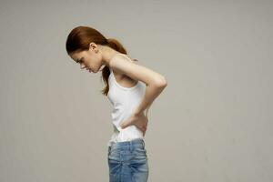 woman in white t-shirt chiropractic rheumatism health problems light background photo