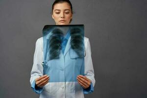 female doctor white coat x-ray examination dark background photo