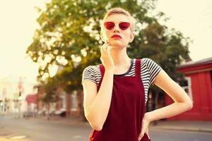 mujer vistiendo Gafas de sol caminando el ciudad verano hogar foto