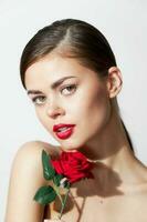 Woman with rose Red lips bared shoulders spa treatments bright makeup photo
