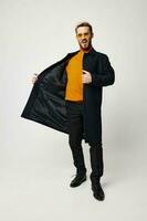 man in dark coat and pants orange sweater fashion style and glasses model photo