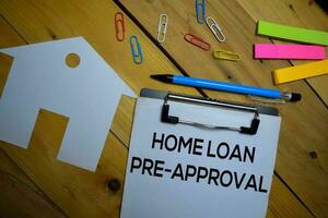 Home Loan Pre-Approval write on a paperwork isolated on wooden background. photo