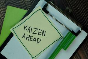 Kaizen Ahead write on sticky notes isolated on Wooden Table. photo