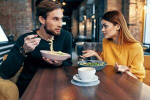 joven Pareja sentado a el mesa comiendo sano estilo de vida comunicación foto