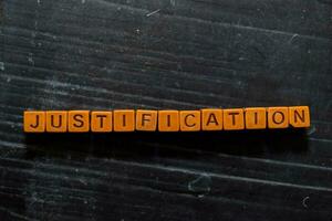 Justification on wooden cubes. On table background photo