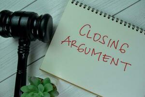 Concept of Closing Argument write on a book with gavel isolated on Wooden Table. photo