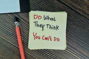 Concept of Do What They Think You Can't Do write on sticky notes isolated on Wooden Table. photo