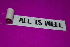 All is Well text, Inspiration and positive vibes concept on purple torn paper photo