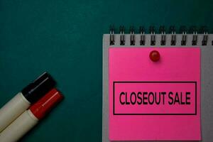 Closeout Sale write on a sticky note isolated on green background. photo