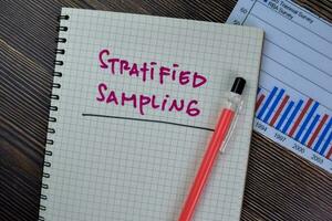 Concept of Stratified Sampling write on a book isolated on Wooden Table. photo