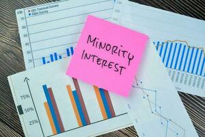 Concept of Minority Interest write on sticky notes isolated on Wooden Table. photo