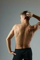 athletic male athlete posing with pumped body back view isolated background photo