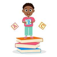 Cute little boy standing on books and holding abc cube. vector