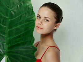 woman in red swimsuit palm leaf in hands attractive look photo