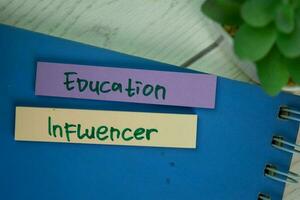 Education Influencer write on sticky notes isolated on Wooden Table. photo