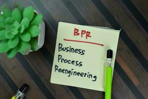 Concept of BPR - Business Process Reengineering write on sticky notes isolated on Wooden Table. photo