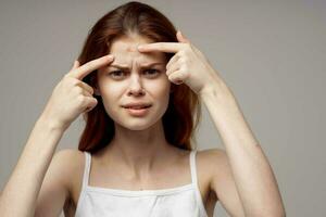 beautiful woman in a white t-shirt pimples on the face isolated background photo