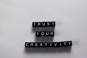 Trust your creativity on wooden blocks. Motivation and inspiration concept photo