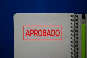 Aprobado write on a book spanish language isolated on blue background. photo