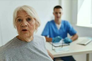 emotional elderly woman in hospital doctor communication treatment photo