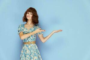 Woman in flower dress smile shows hands to the side summer clothes photo