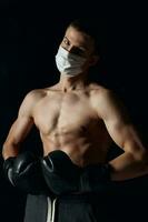 portrait of sportsman wearing boxing gloves and medical mask close-up cropped view photo