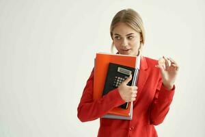 woman in a red jacket with documents in hand light background photo