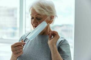 an elderly woman puts a mask on her face hospital photo