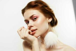 woman with bare shoulders in fluffy earrings jewelry Glamor bright makeup photo
