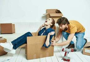 Man and woman boxes with things white sofa interior moving room photo