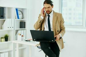 handsome man in the office with a laptop lifestyle photo