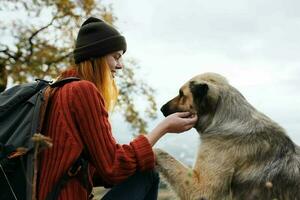 mujer viajes en el montañas con un perro caminar amistad otoño foto