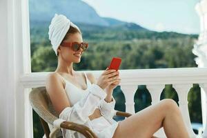 retrato de maravilloso mujer sentado en el balcón hablando en el teléfono inalterado foto