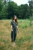 Woman in the forest in the meadow gray jumpsuit photo