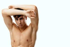 young couple with pumped up muscles bodybuilder hands behind head and white background photo