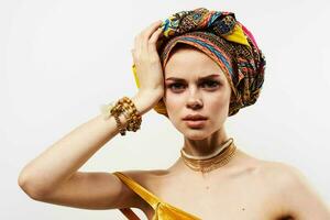 pretty woman holding her head decoration multicolored turban fashion light background photo