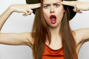 Portrait of a woman in a hat Emotions gestures with hands open mouth photo