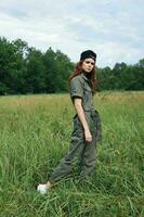 woman outdoors Tall grass in fresh air in green overalls photo