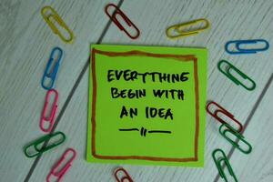 Everything Begin With An Idea write on sticky notes isolated on office desk. photo