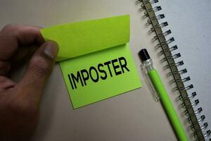 Imposter text on sticky notes isolated on office desk photo